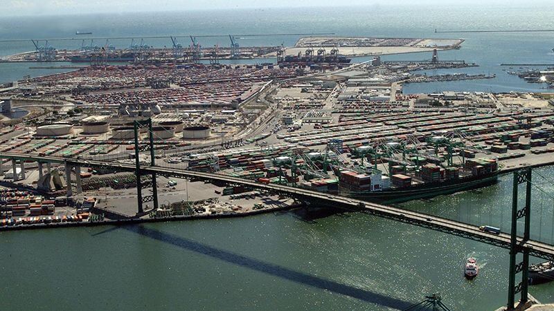 An aerial view of a port with a bridge. 