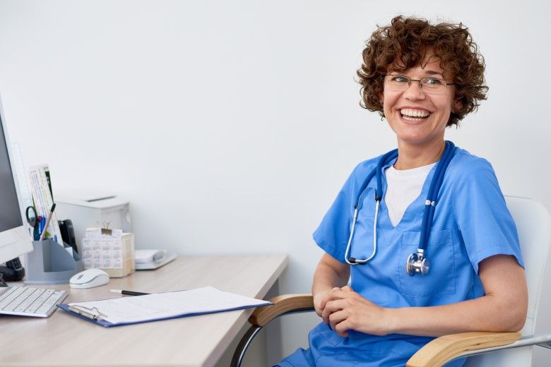 A nurse educator assisting a nurse with a chart in a medical facility.